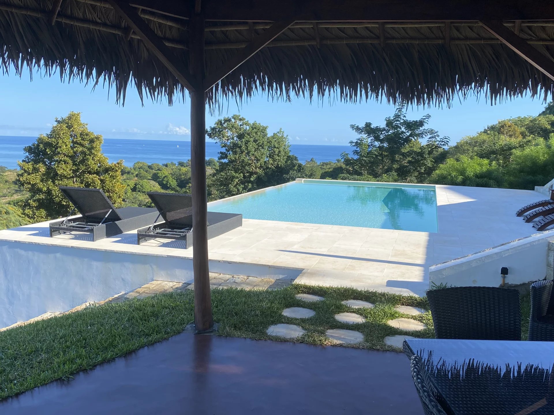 Villa avec piscine à Nosy Be Vue de la piscine et du jardin avec océan en arrière-plan à Nosy Be, Madagascar.
