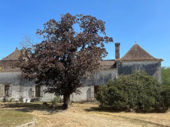 Bâtiment ancien avec un arbre devant, situé sur un domaine équestre à Ménesplet, Dordogne.