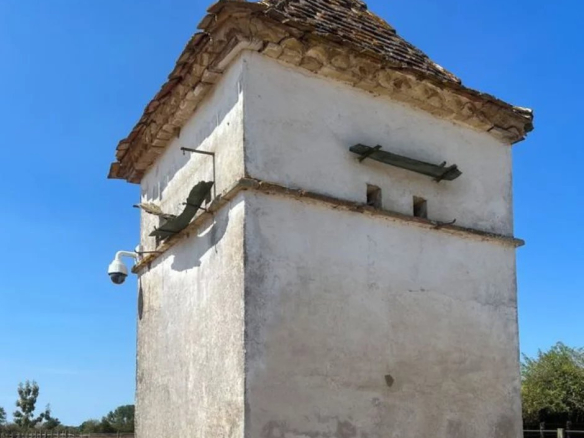 Tour en pierre avec un toit en tuiles, située dans un domaine équestre à Ménesplet, Dordogne.