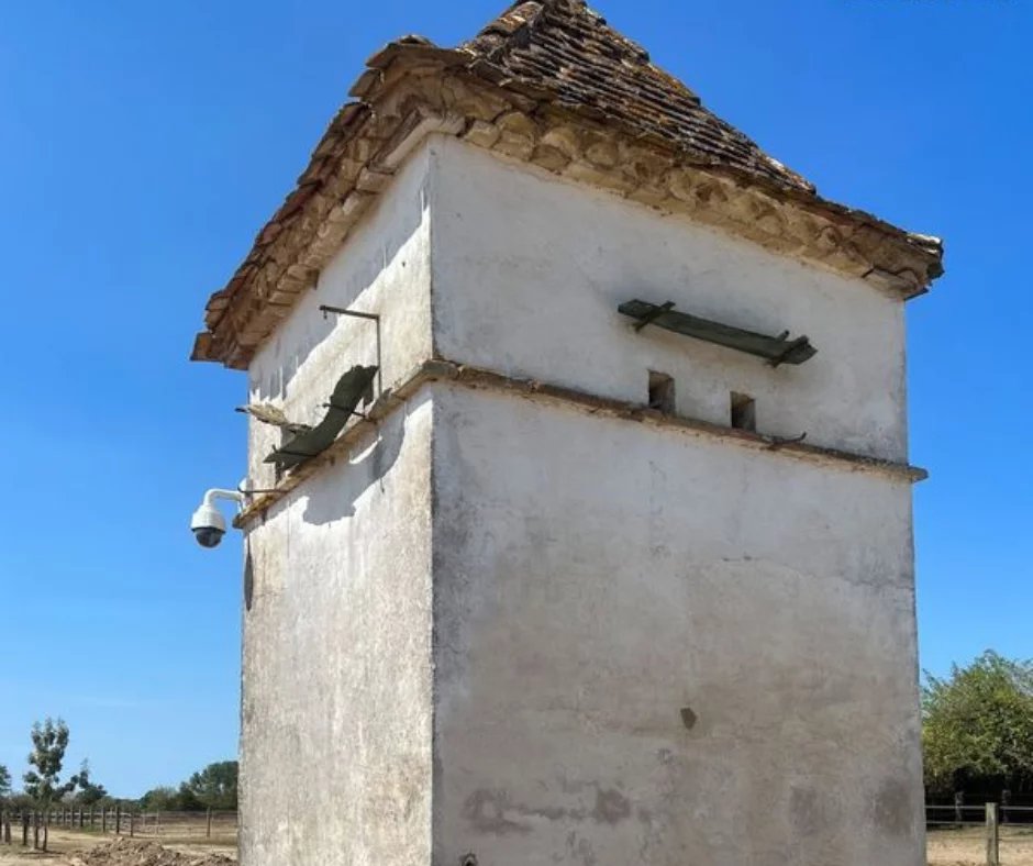 Tour en pierre avec un toit en tuiles, située dans un domaine équestre à Ménesplet, Dordogne.