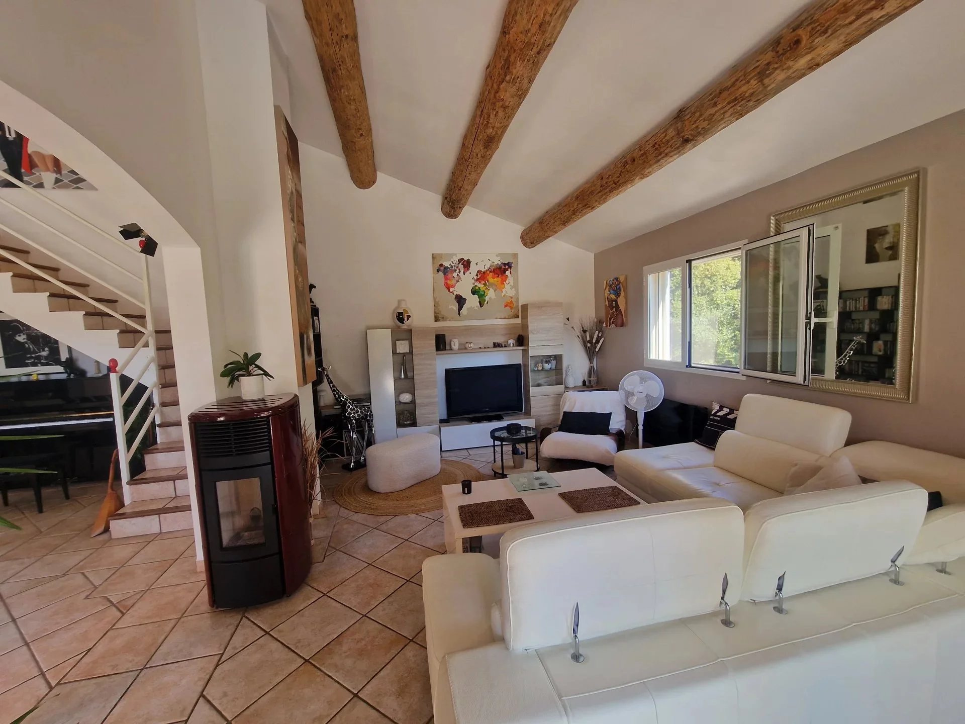 Interior of the villa in Marine de Solaro Interior of a villa with bright living room, fireplace and staircase, Marine de Solaro, Corsica.