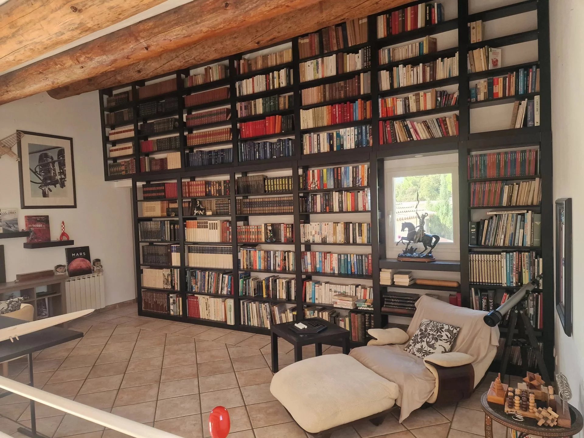 Interior of the villa in Marine de Solaro Interior of a villa with a library filled with books and a comfortable seating area.