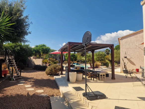 Terrace of a villa with swimming pool in the Marina di Solaro, surrounded by vegetation.