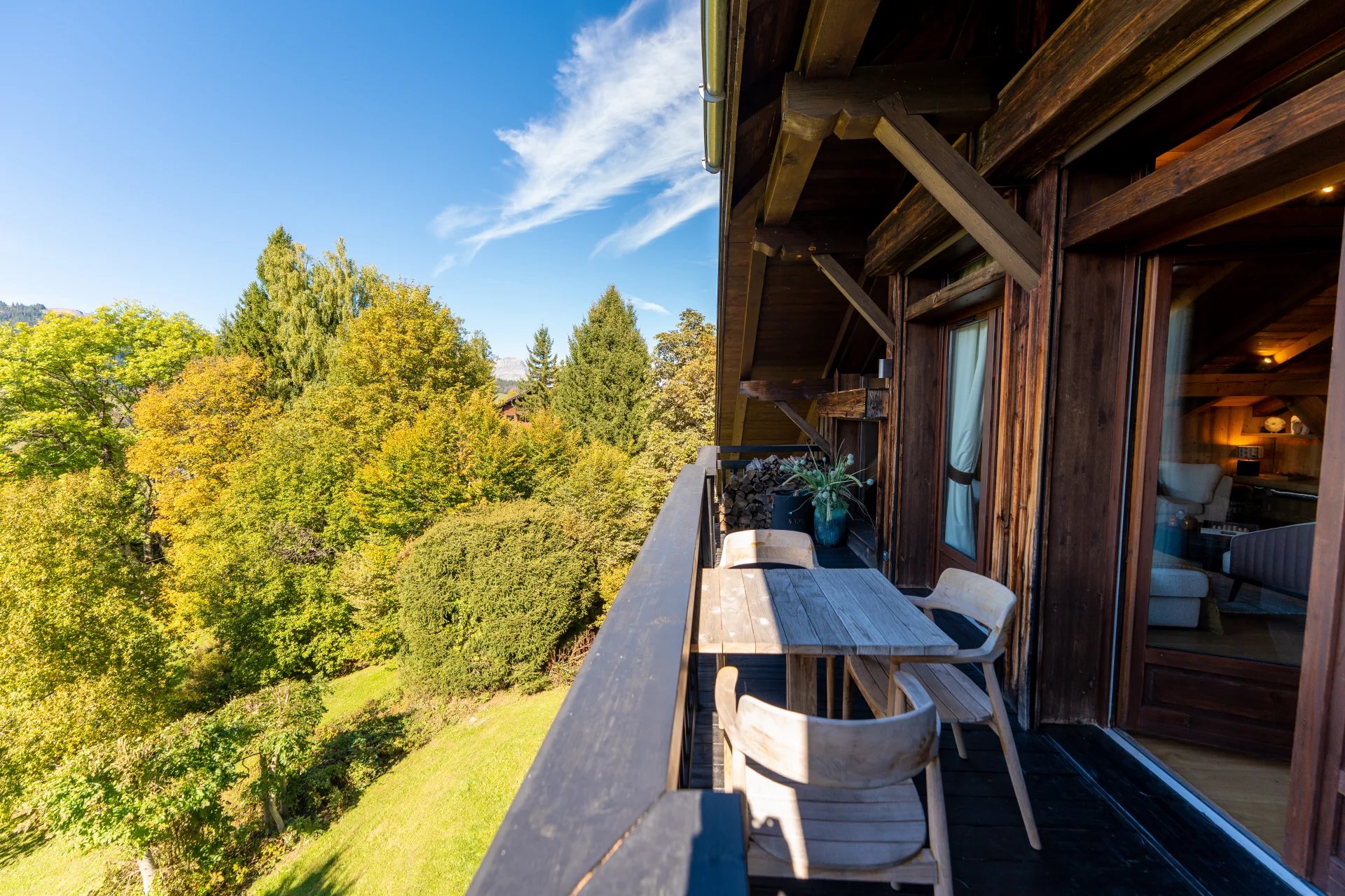 Balcon d’un appartement à Megève Balcon d'un appartement à Megève avec vue sur la nature environnante et mobilier en bois.