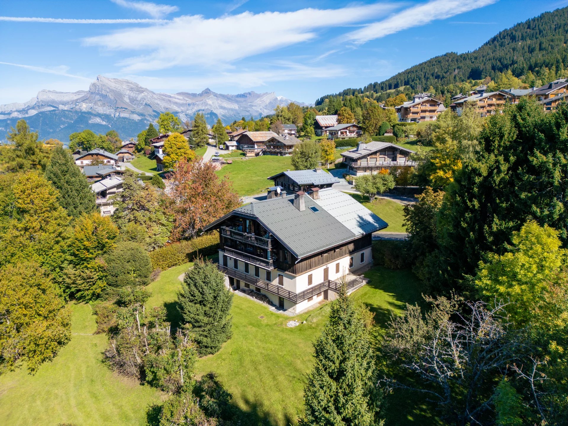 Appartement de prestige à Megève Vue aérienne d'un appartement de prestige à Megève, entouré de verdure et de montagnes.