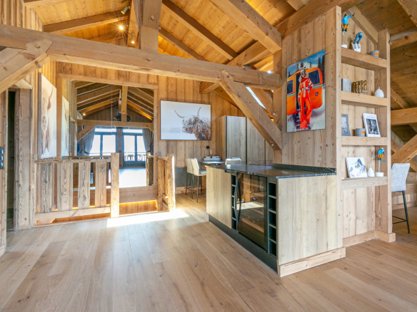 Intérieur d'un appartement en bois avec cuisine ouverte et séjour lumineux à Megève.