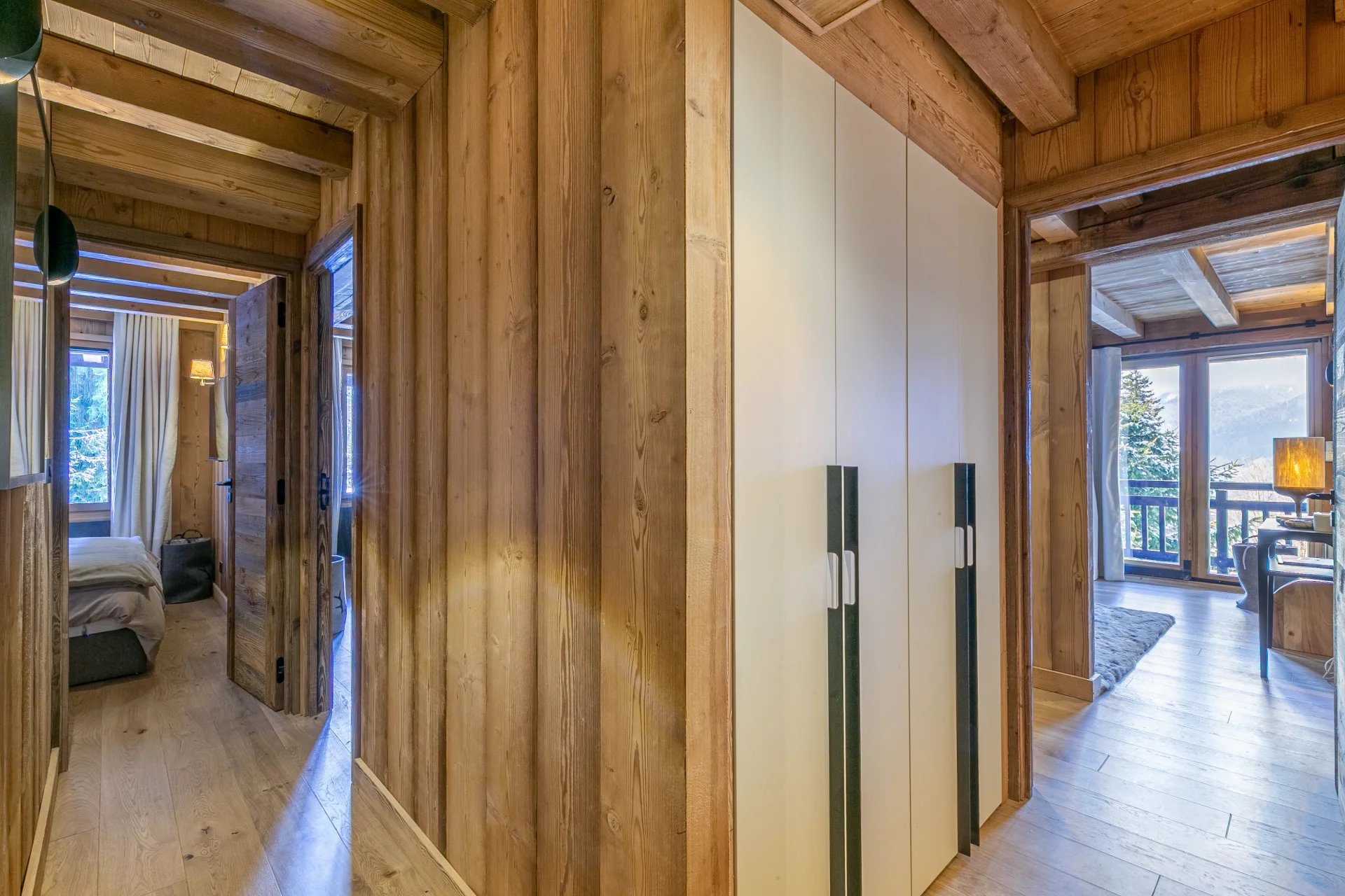 Appartement de prestige à Megève Intérieur d'un appartement en bois à Megève avec couloir et placards.