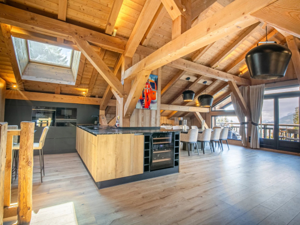 Intérieur d'un appartement de prestige à Megève, avec un séjour cathédrale et une cuisine moderne.