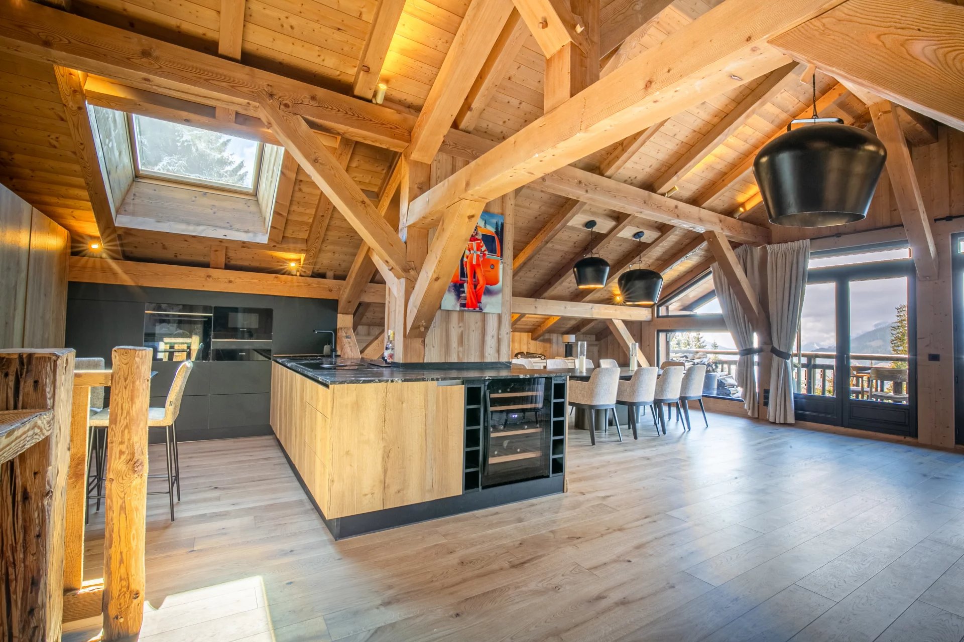 Appartement de prestige à Megève Intérieur d'un appartement de prestige à Megève, avec un séjour cathédrale et une cuisine moderne.