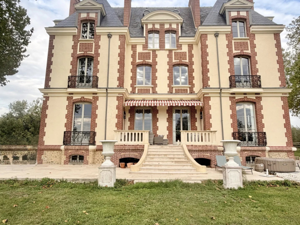 Château équestre de style normand avec façade en brique et pierre, situé sur un domaine de 7,8 ha.