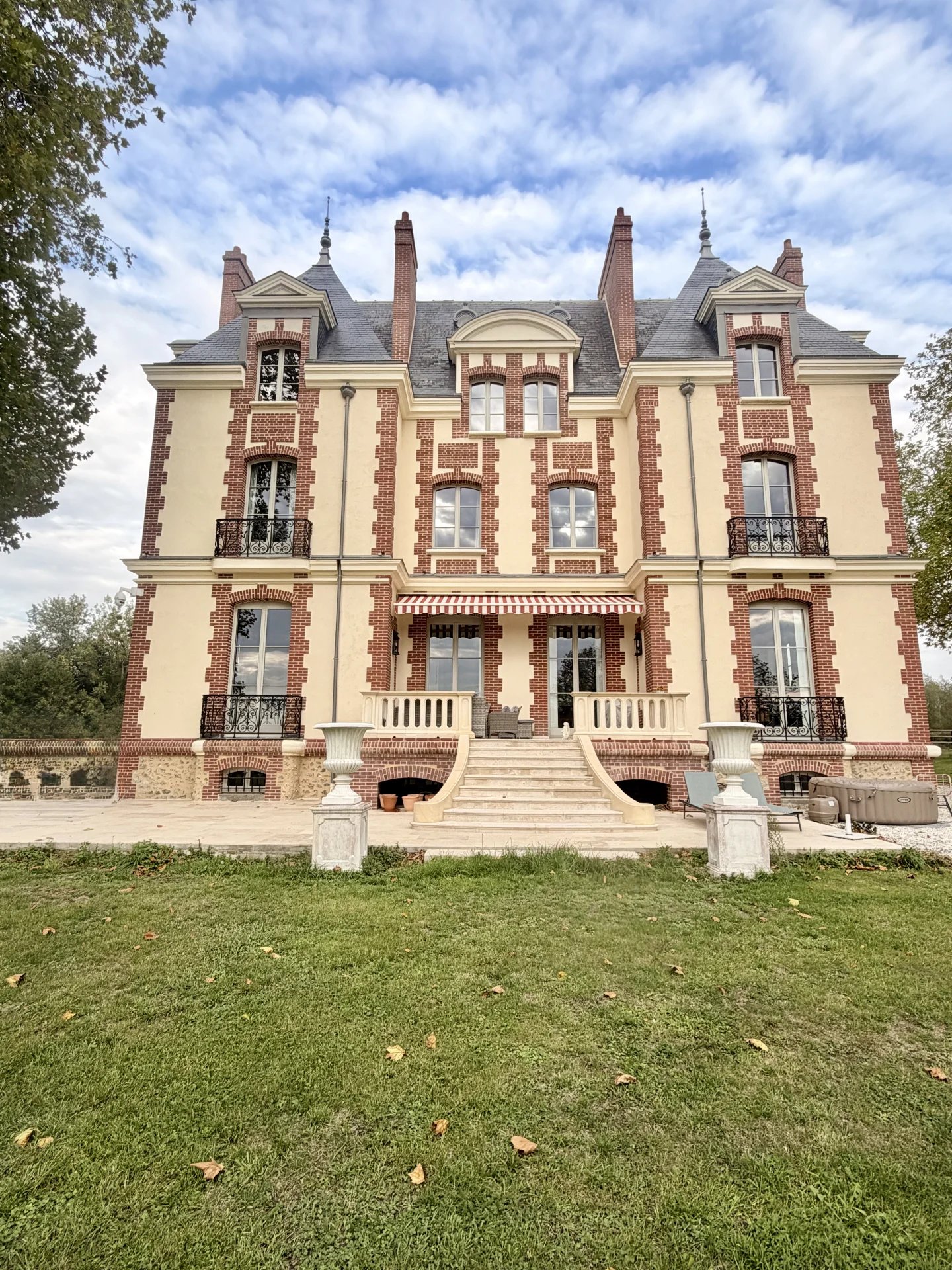Château équestre de style normand avec façade en brique et pierre, situé sur un domaine de 7,8 ha.