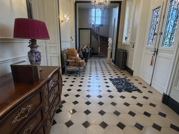 Intérieur d'un château avec un hall d'entrée en marbre et des éléments décoratifs.