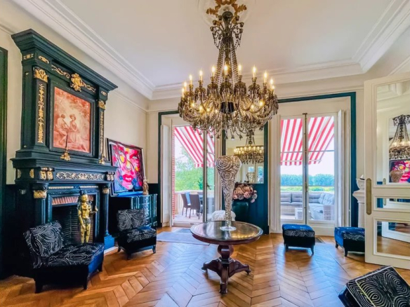 Intérieur d'un château avec un lustre, des fauteuils et des fenêtres à rideaux rayés.