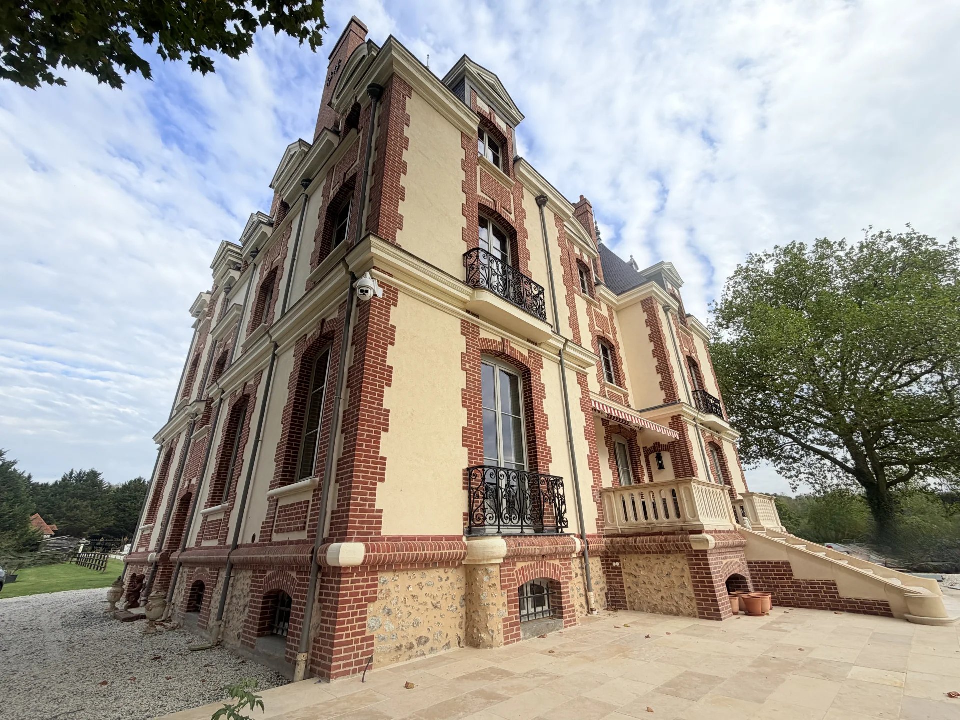 Château de style normand en pierre et brique, entouré d'un domaine verdoyant près de Pont-l'Évêque.