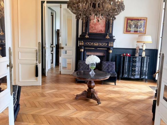 Intérieur d'un château avec un sol en parquet, un lustre et un mobilier élégant.