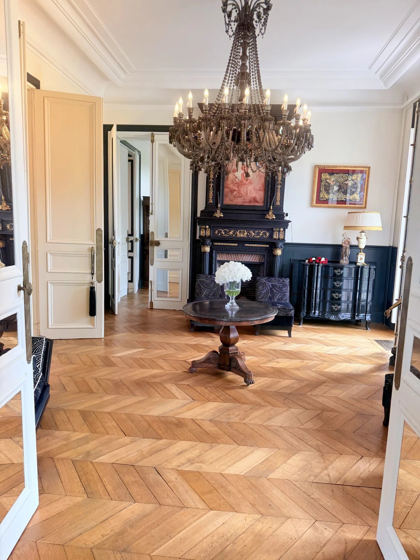 Intérieur d'un château avec un sol en parquet, un lustre et un mobilier élégant.