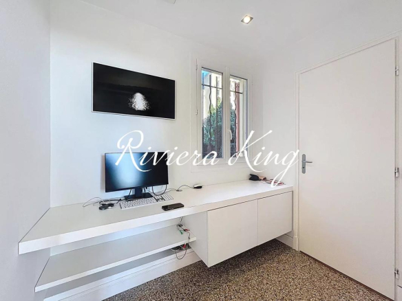 Minimalist white home office with a wall-mounted desk, computer monitor, keyboard, and floating shelves under a window and door.