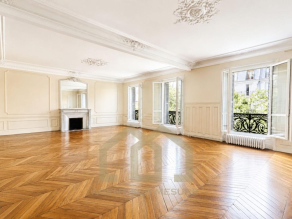 Intérieur d'un appartement de 160 m² avec parquet en bois et grandes fenêtres à Paris 5ème.