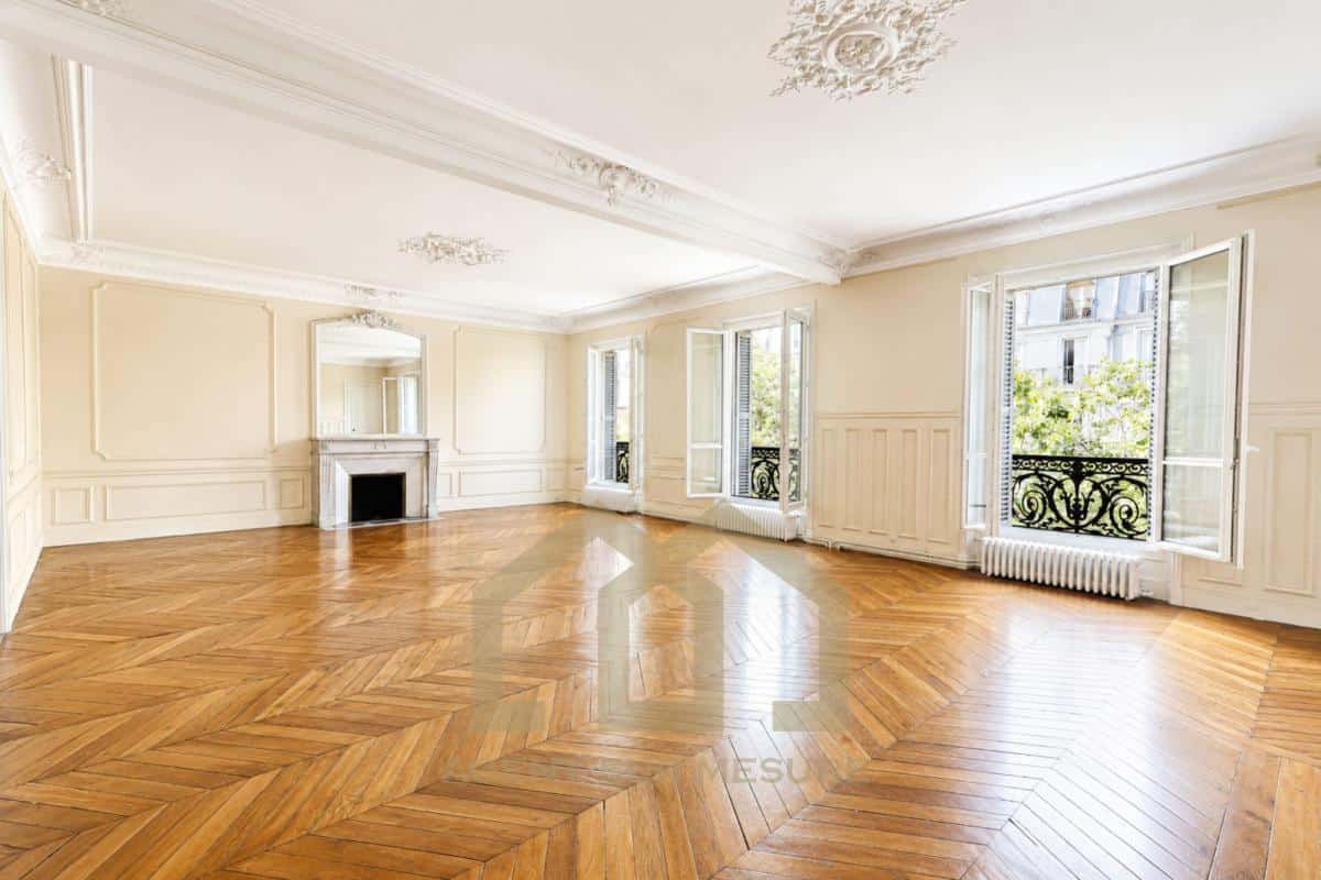Intérieur d'un appartement de 160 m² avec parquet en bois et grandes fenêtres à Paris 5ème.