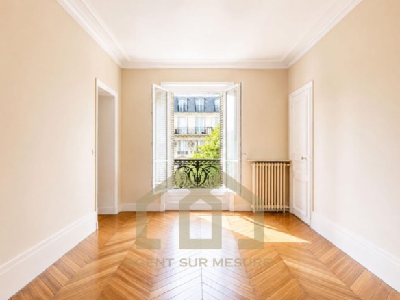 Intérieur d'un appartement de 160 m² avec parquet et fenêtres donnant sur un balcon, Paris 5ème.