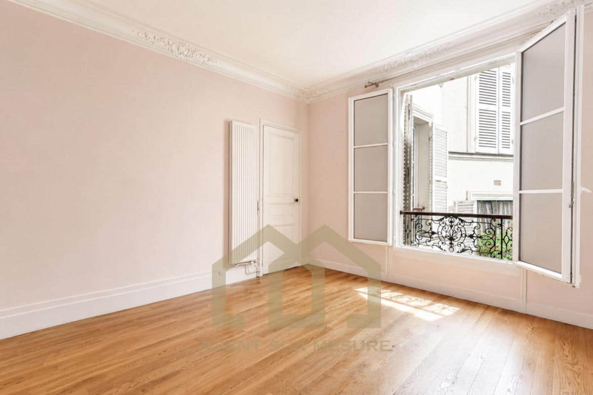 Intérieur d'un appartement vide avec fenêtres ouvertes et parquet au 5ème arrondissement de Paris.