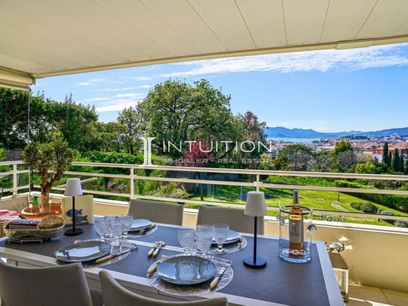Terrace of an apartment in Cannes with sea and city views, garden furniture installed.