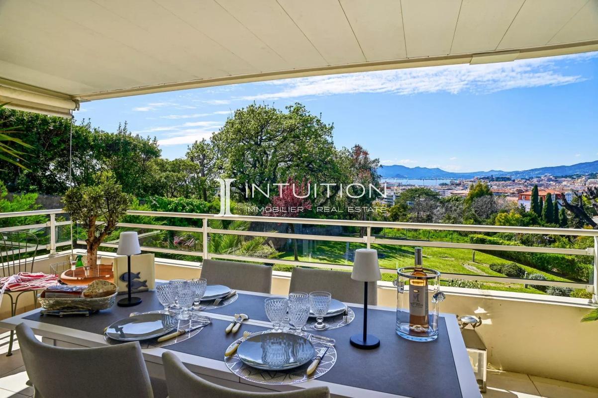 Terrace of an apartment in Cannes with sea and city views, garden furniture installed.
