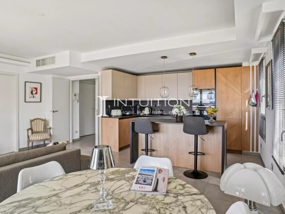 Interior of a modern apartment with open kitchen and dining area, sea view.