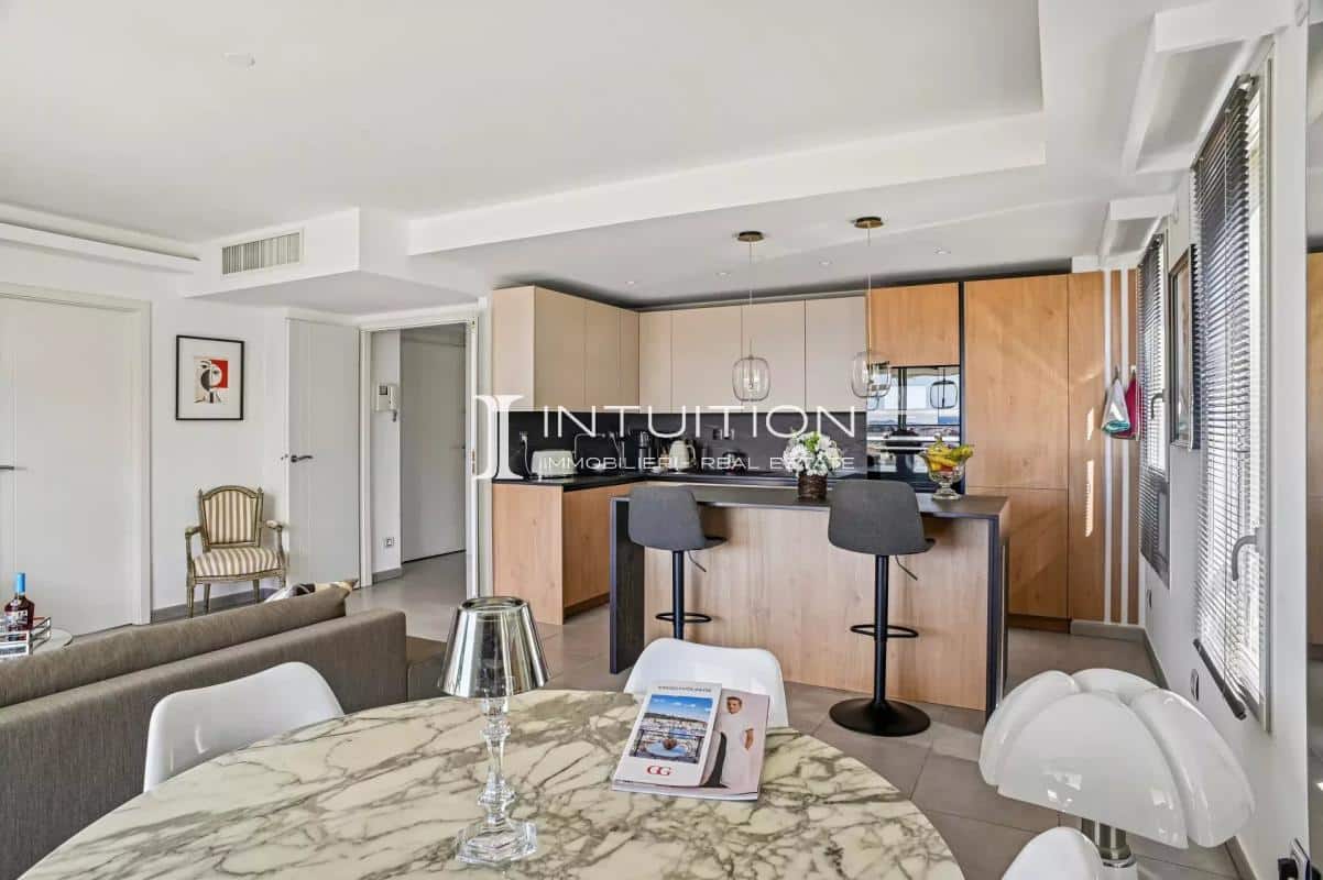 Interior of a modern apartment with open kitchen and dining area, sea view.