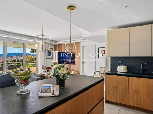 Interior of a modern apartment with open kitchen and living room, sea view in Cannes.