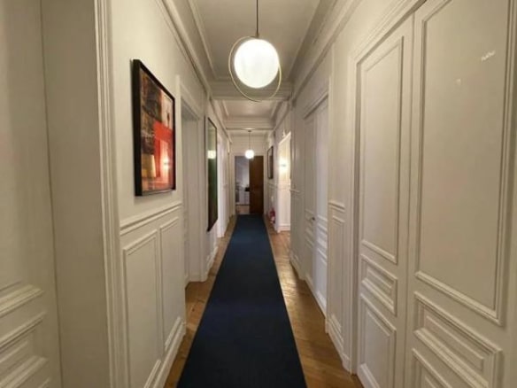 Couloir d'un appartement à Paris avec parquet et moulures, éclairage moderne