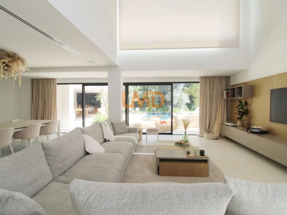 Intérieur d'une villa contemporaine à Thuir, salon lumineux avec canapé et baies vitrées donnant sur l'extérieur.