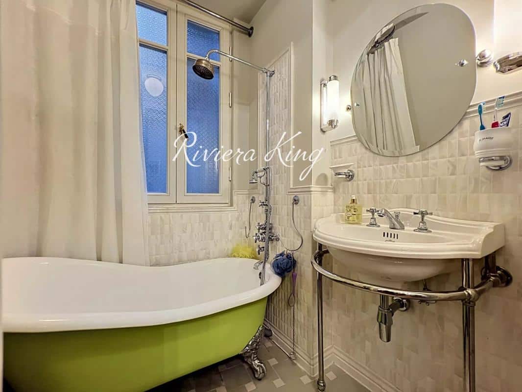 Salle de bain avec baignoire sur pieds et lavabo, lumière naturelle