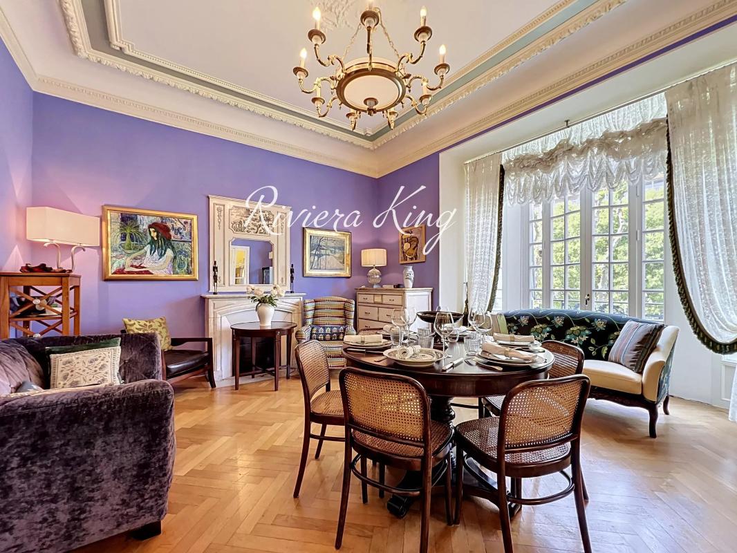 Salon d'un appartement de style Belle Époque avec mobilier élégant et lumière naturelle à Nice.