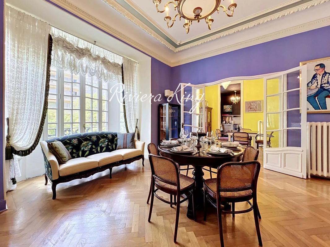 Salon d'un appartement de style Belle Époque avec parquet, moulures et lumière naturelle à Nice.