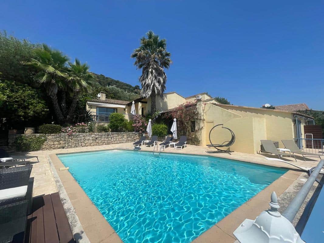 Maison avec piscine et palmiers à Gattières, vue dégagée sur les hauteurs.