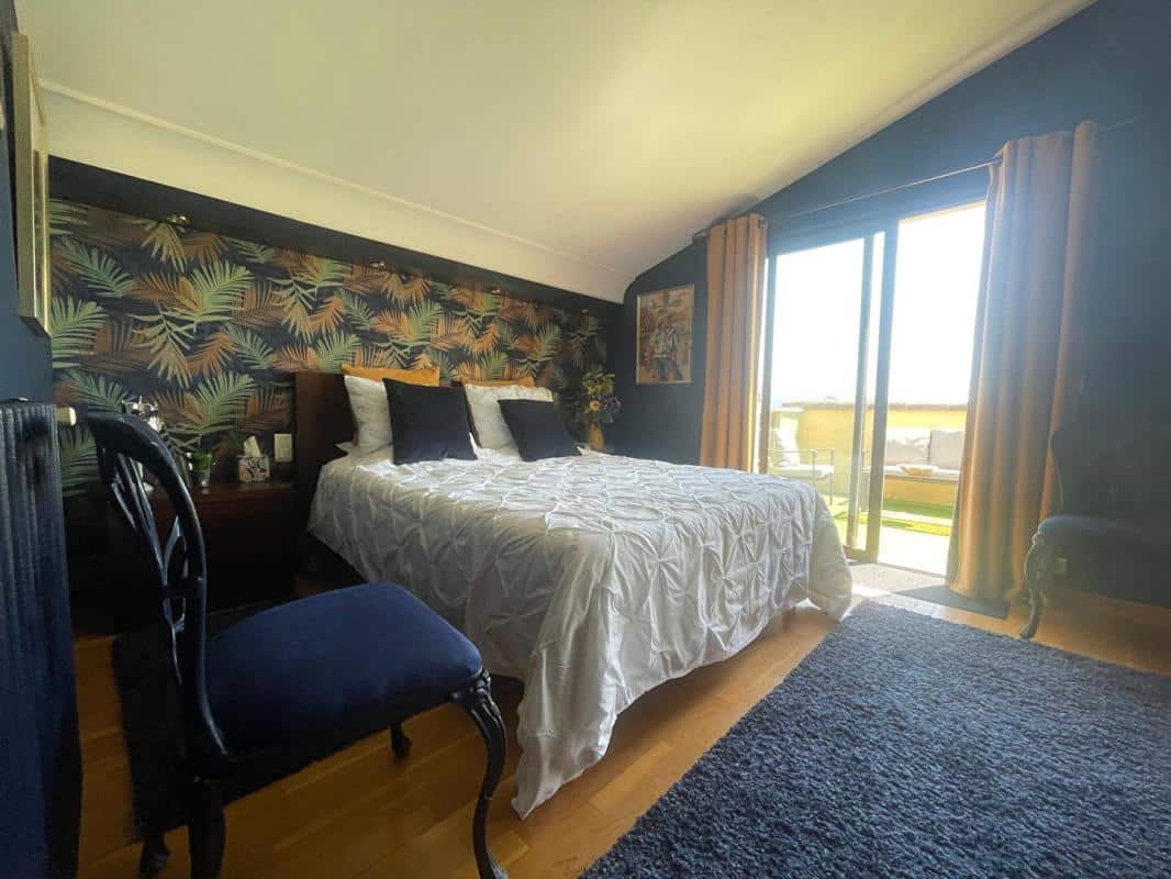Chambre d'une maison à Gattières avec un lit double et accès à un balcon.