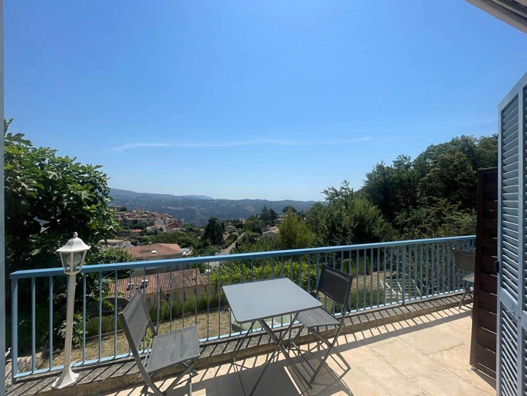 Terrasse avec vue dégagée sur la vallée à Gattières, table et chaises en métal.