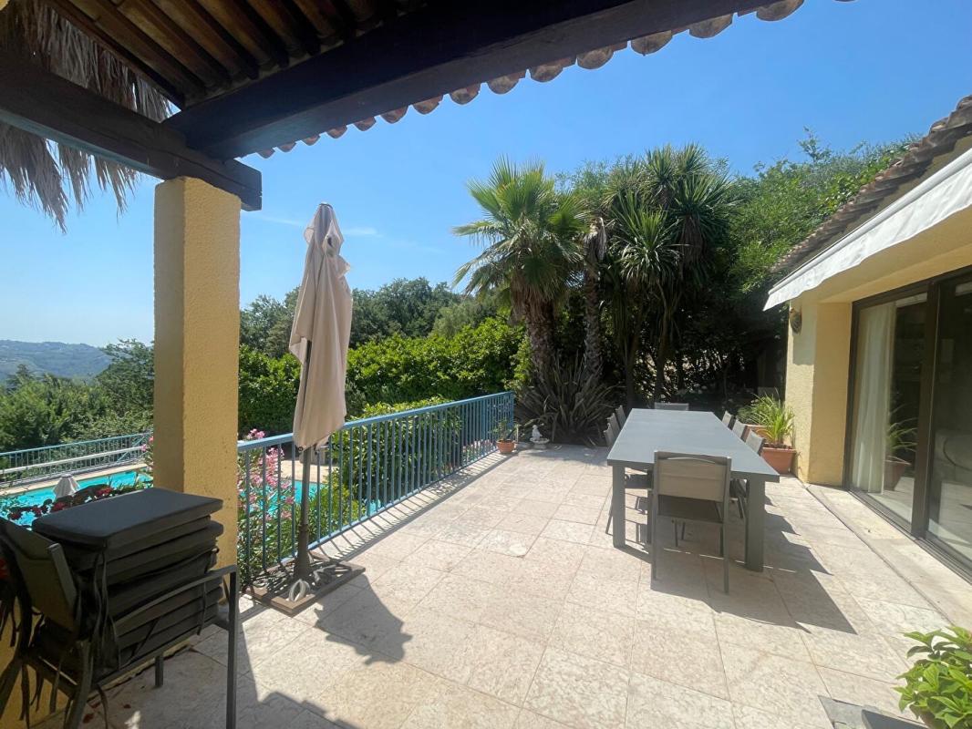 Terrasse de maison avec vue sur la piscine et végétation luxuriante à Gattières.