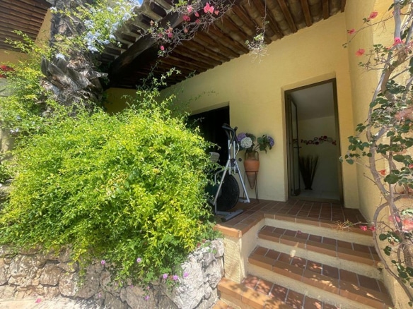 Entrée de la maison Gattieres avec des plantes et des escaliers en pierre.