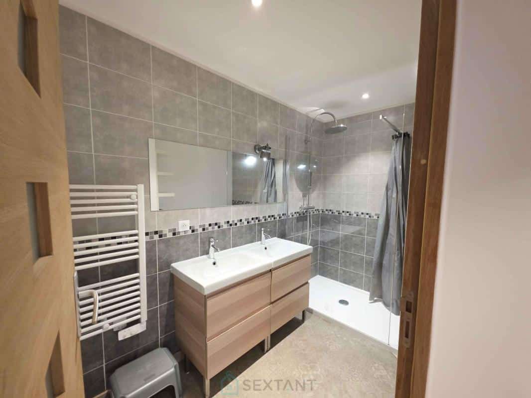 Modern bathroom with double sink and shower, grey tiles, in Saint-Jean-de-Marsacq.