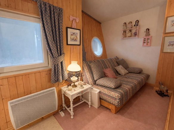 Intérieur d'un triplex au Thuya à Avoriaz, avec un canapé et des décorations murales.