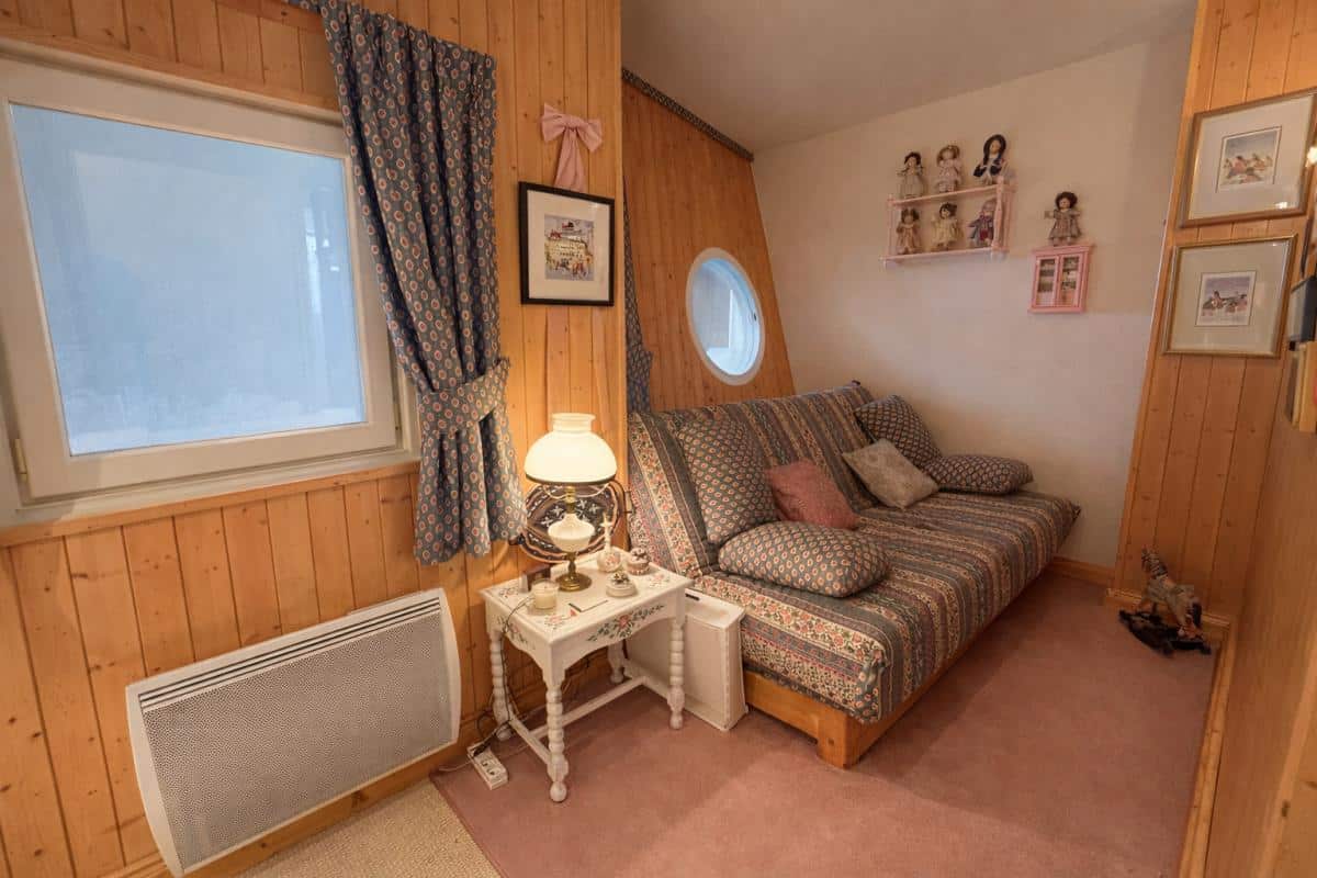 Intérieur d'un triplex au Thuya à Avoriaz, avec un canapé et des décorations murales.