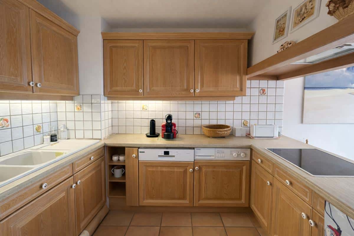 Cuisine en bois avec évier, lave-vaisselle et plaques de cuisson, dans un appartement à Avoriaz.