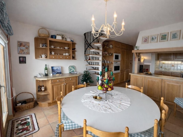 Intérieur d'un triplex à Avoriaz avec salle à manger, cuisine et escalier en colimaçon.