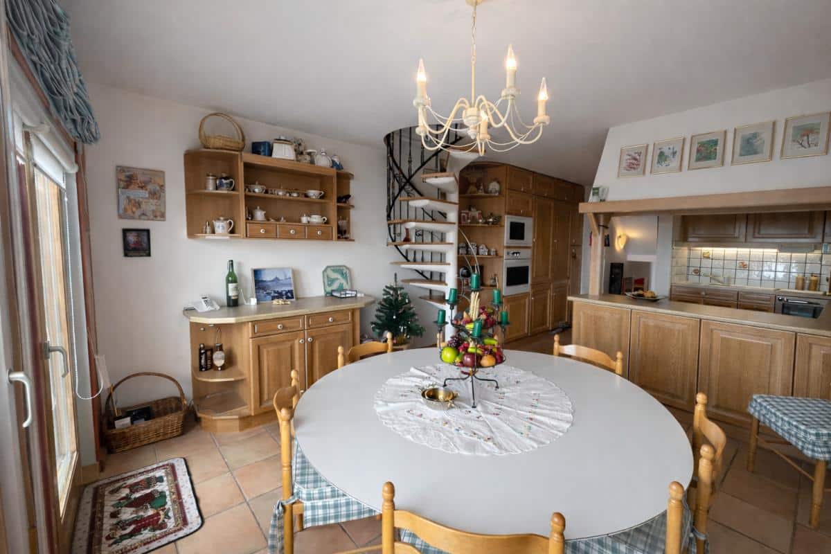 Intérieur d'un triplex à Avoriaz avec salle à manger, cuisine et escalier en colimaçon.