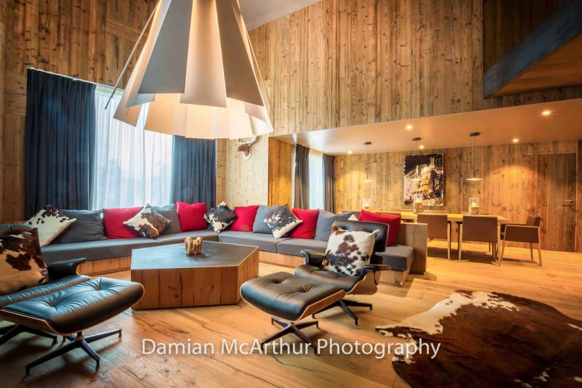 Interior of a modern loft with a spacious living room, wooden furniture and contemporary decor.