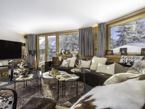 Intérieur du chalet de la Combe à Avoriaz, salon avec canapés et vue sur la neige.