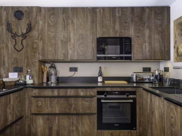 Cuisine moderne en bois avec équipements intégrés dans un chalet.