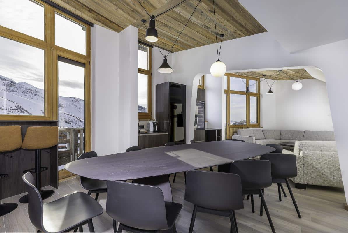 Intérieur d'un penthouse duplex à Avoriaz avec vue sur les montagnes, salle à manger moderne et lumineuse.